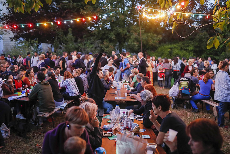 des tables, des gens qui mangent, des lumières